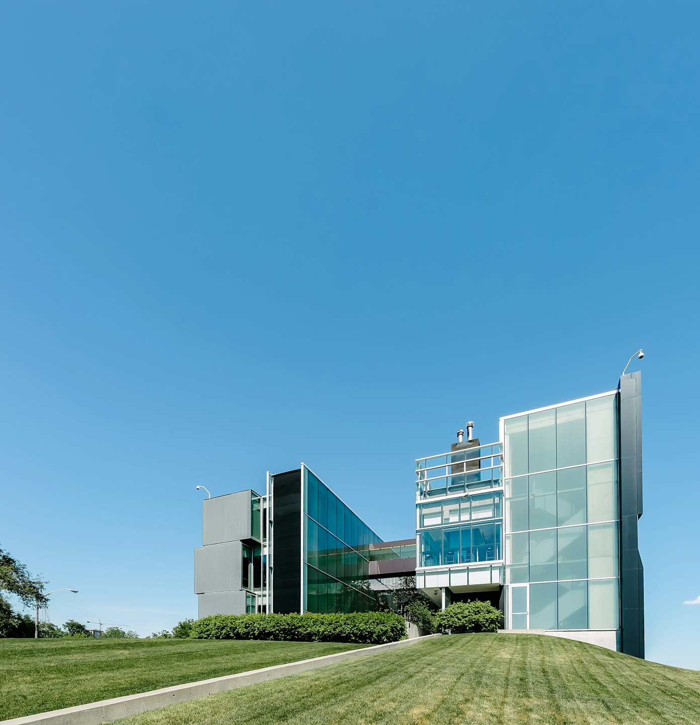 Contatti Moderno edificio per uffici in vetro e grigio dal design geometrico.