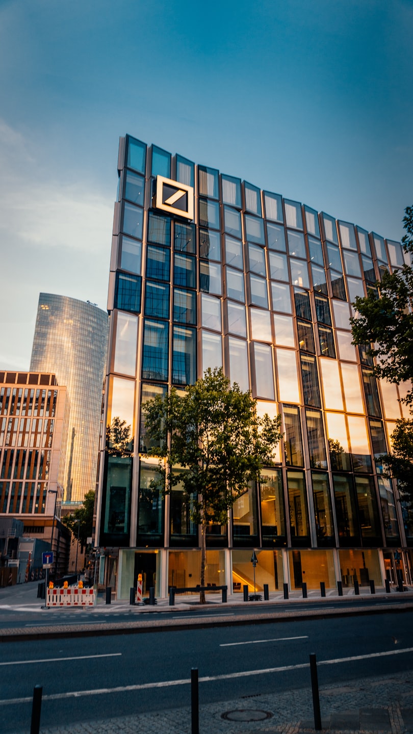 Contatti Edificio moderno con logo aziendale che riflette il tramonto.